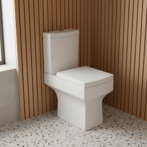 White toilet in a bathroom with wooden paneling and speckled floor.