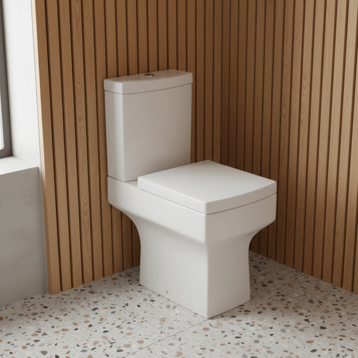 White toilet in a bathroom with wooden paneling and speckled floor.