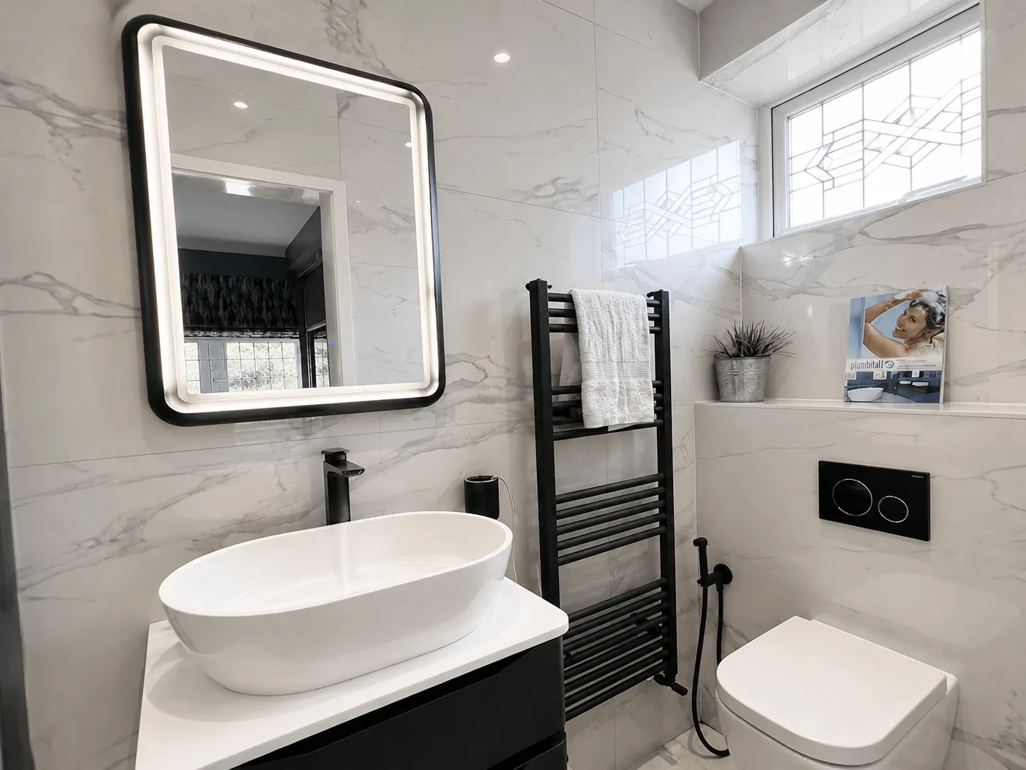 Marble-effect bathroom with a countertop basin and black towel radiator