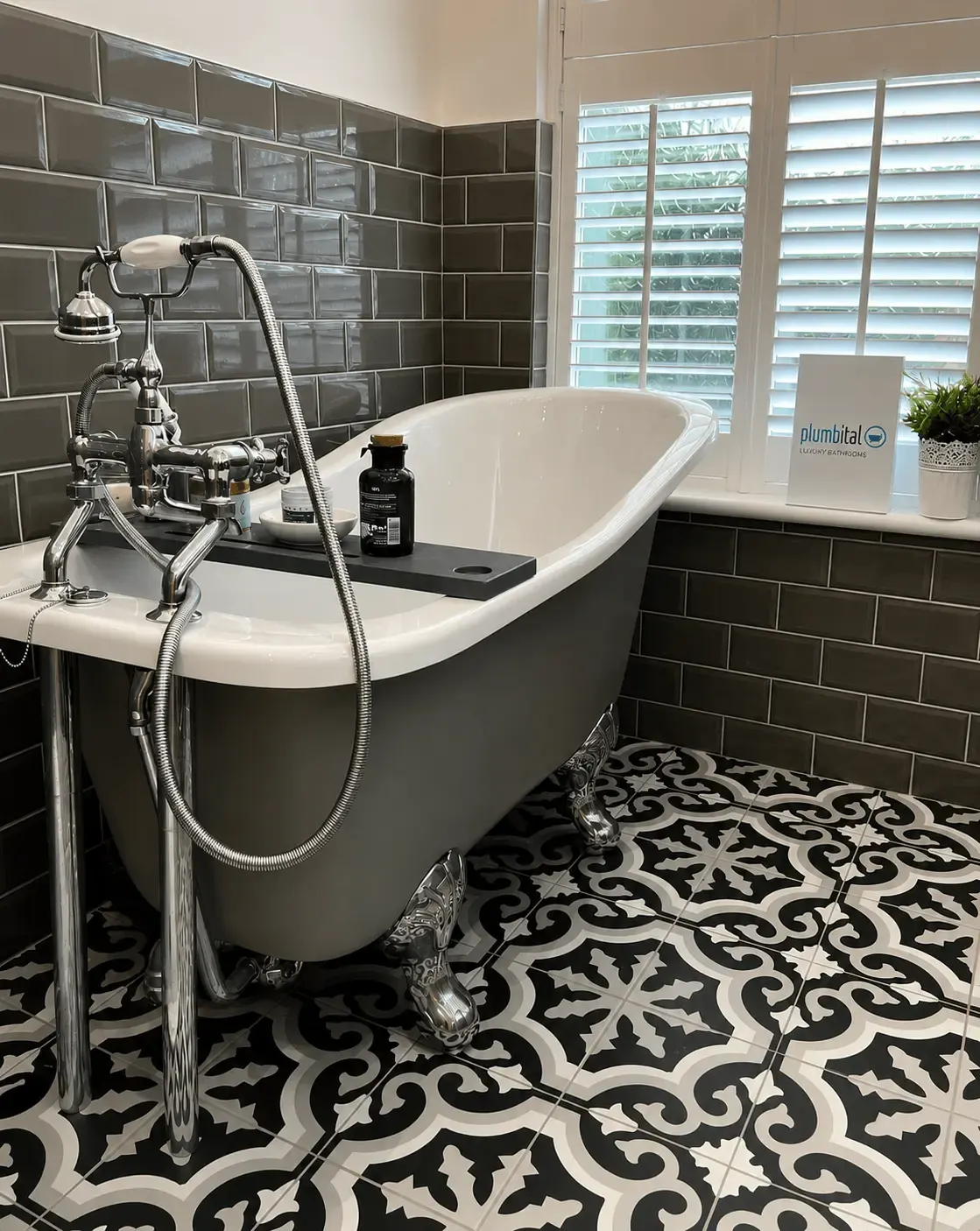 Traditional roll-top bath with chrome taps and a black-and-white patterned floor