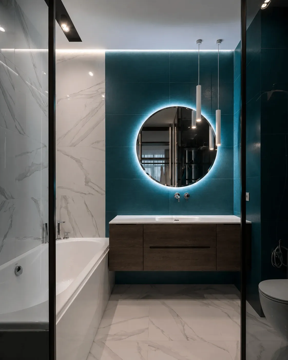 Bathroom with a teal feature wall, wood-effect vanity and round illuminated mirror