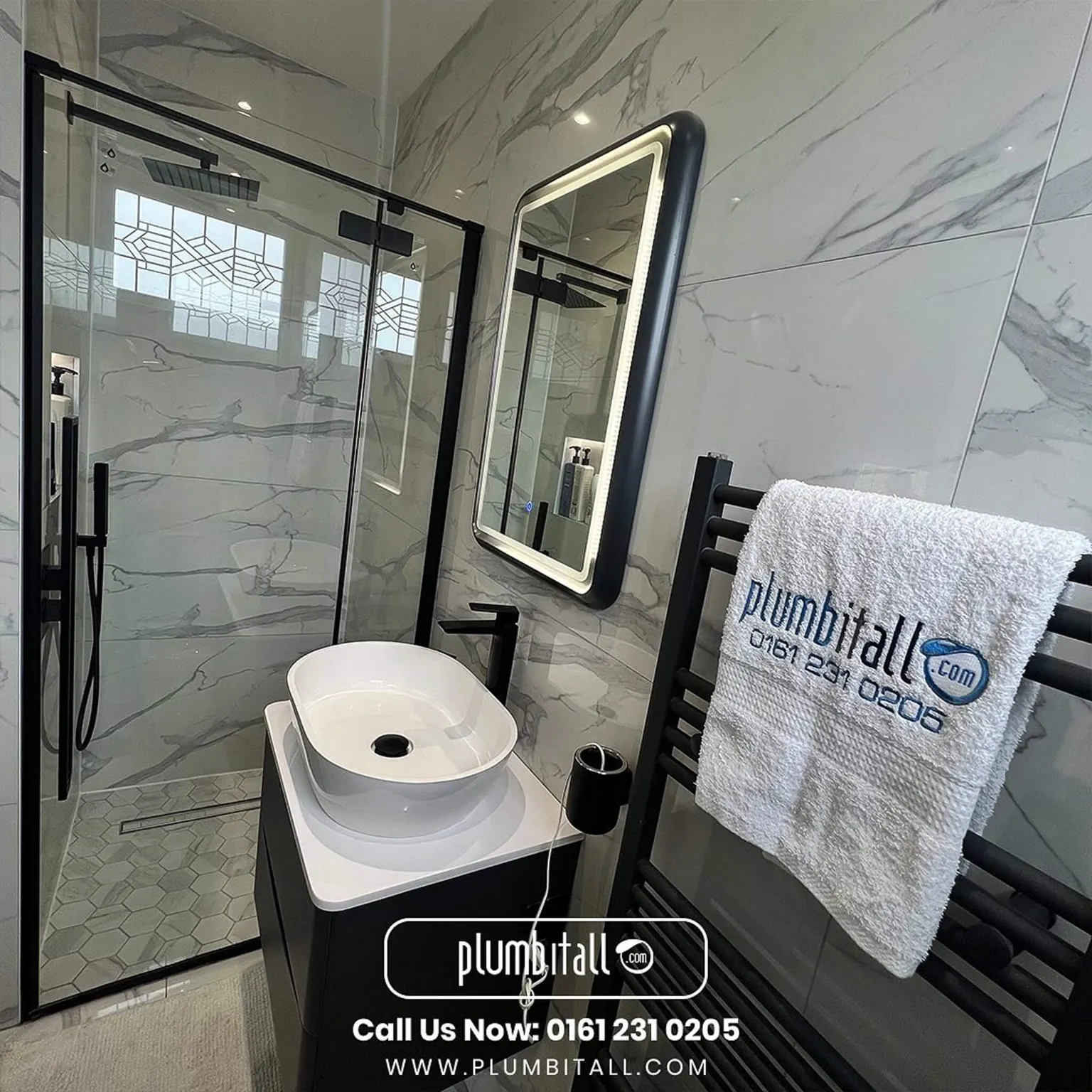 Marble-effect ensuite with black-framed shower enclosure and countertop basin