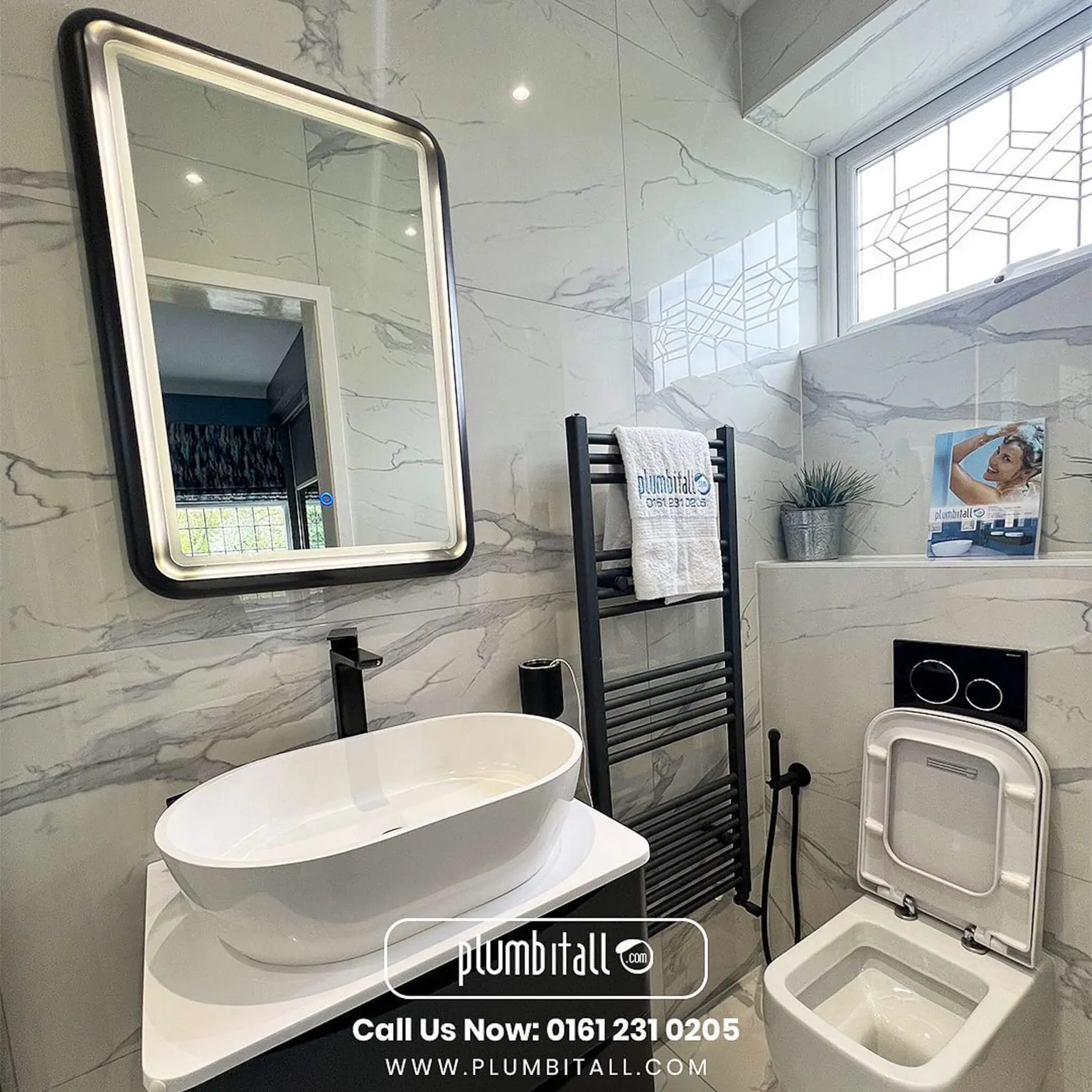 Marble-effect ensuite with an oval countertop basin and illuminated mirror