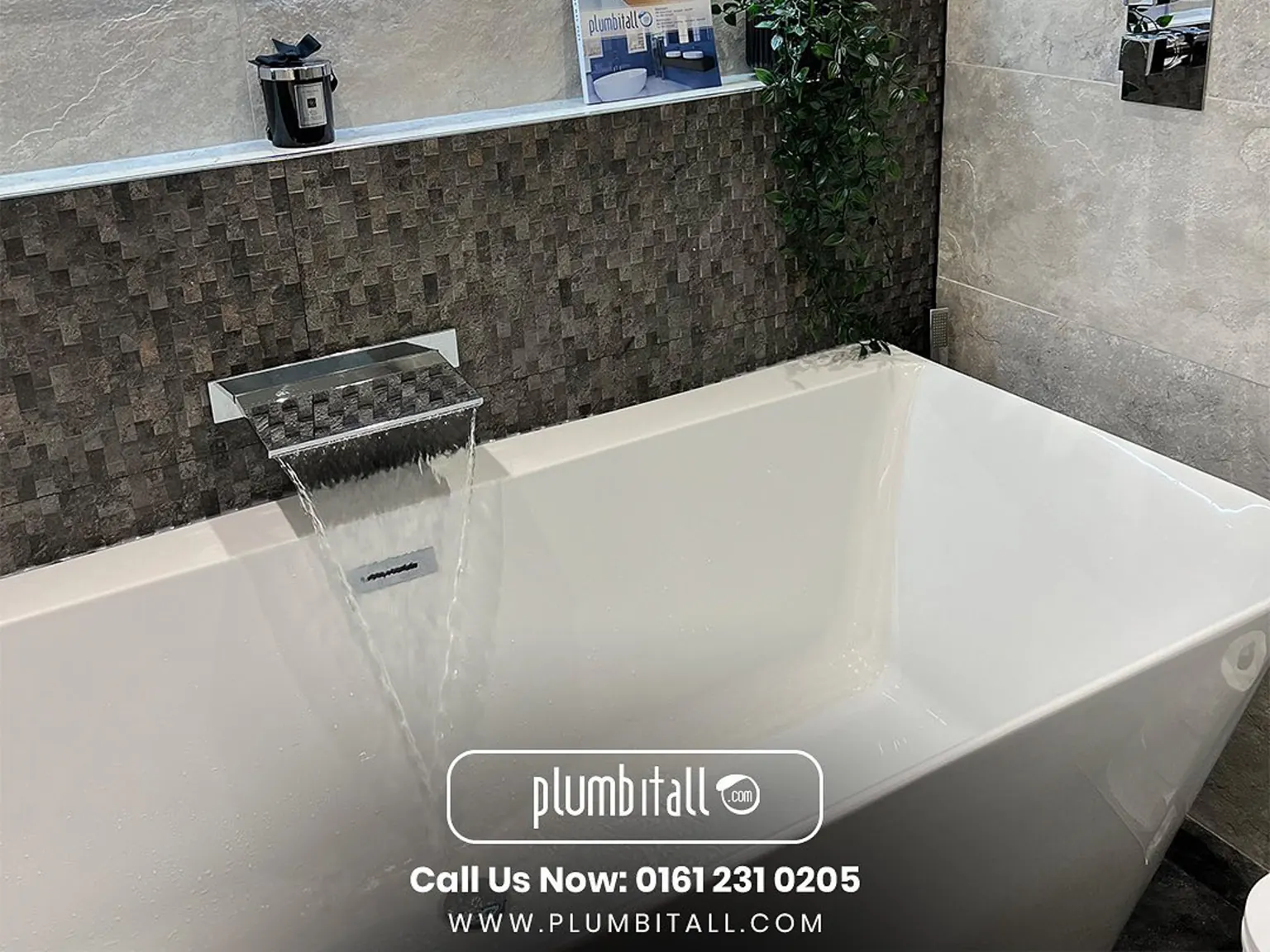 Freestanding bath with a waterfall tap and mosaic-tiled feature wall