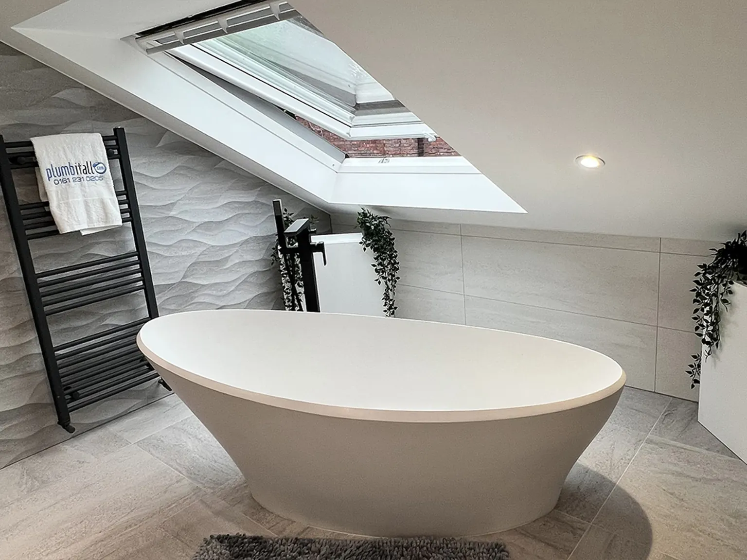 Family bathroom with a freestanding bath beneath a roof window
