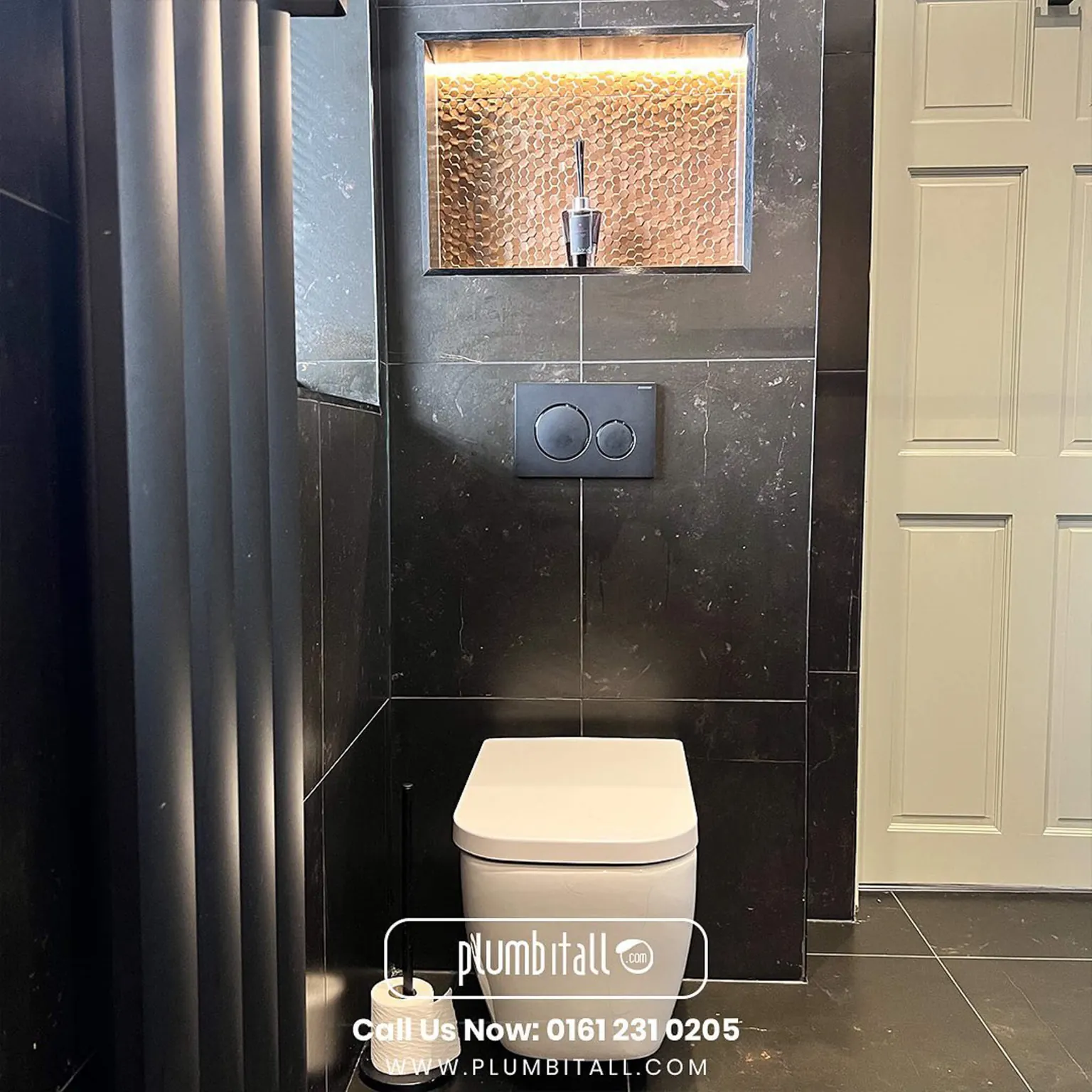 Wall-hung toilet beneath a bronze mosaic recess in a wet room