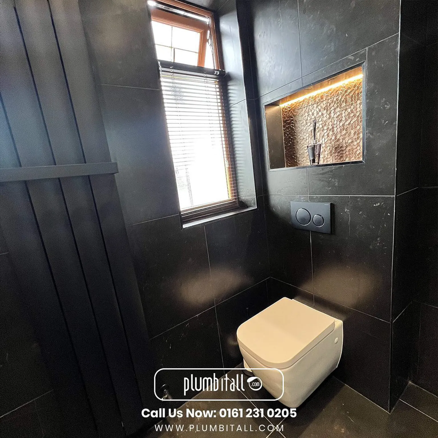 Wall-hung toilet beside a tall black radiator in a dark tiled wet room