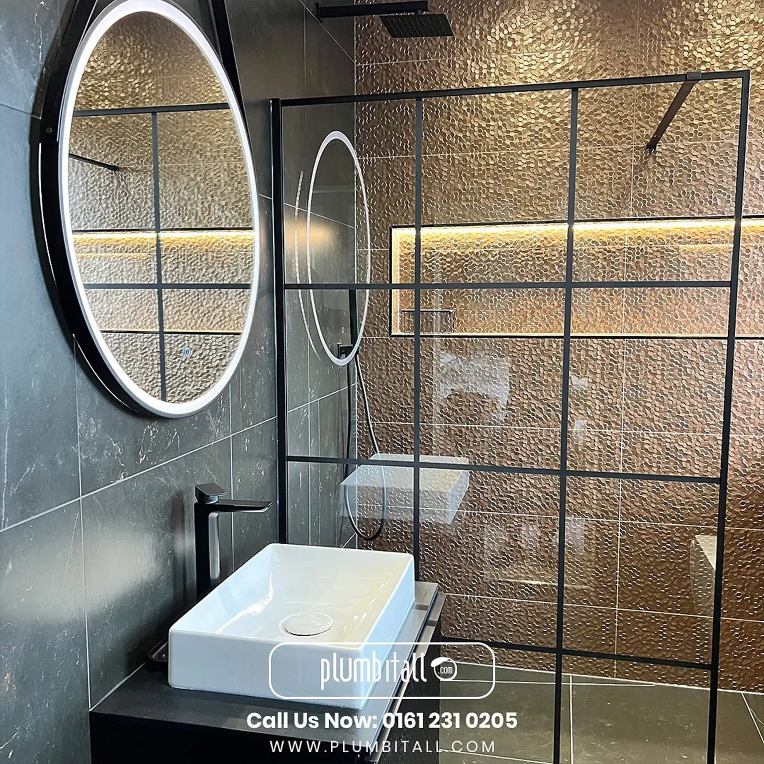 Wet room with a black-framed shower screen and illuminated bronze feature wall