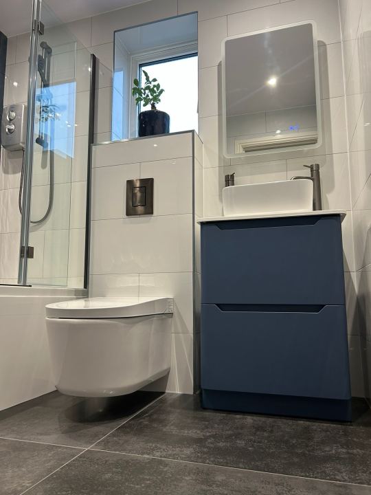 Swipe to see more ➡️ This recent renovation by our team is all about colour done right. A teal feature wall frames the bath, the navy vanity…